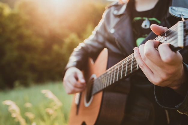 Man playing guitar in nature on a sunny day