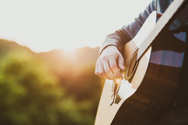 Man playing guitar in nature on a sunny day