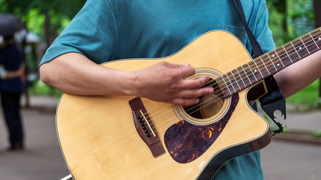 公園で屋外でギターを弾く男