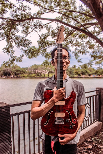 Foto uomo che suona la chitarra sulla ringhiera