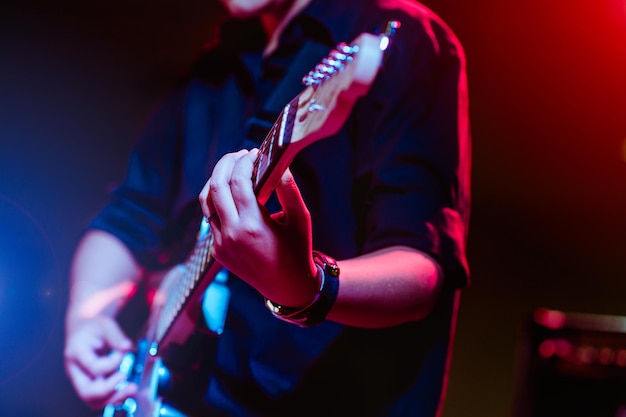 Man playing guitar on a stage musical concert close-up view.guitarist plays.