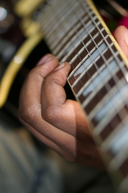 Мужчина играет на гитаре с пальцами на струнах