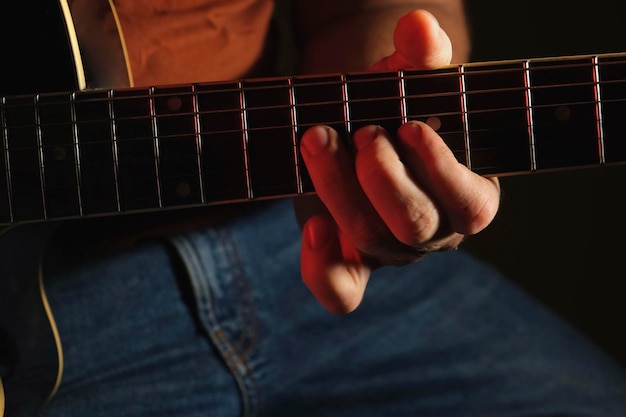 Uomo che suona la chitarra con la luce al neon. persona irriconoscibile che prova. chitarra acustica strimpellata. mus