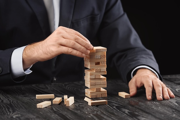 Man playing jenga game on table Management concept