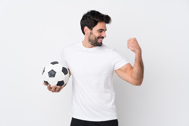 Man playing soccer over isolated wall