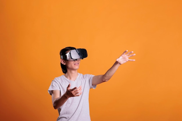 Uomo che gioca a giochi di realtà virtuale con occhiali vr, esplorando il metaverso. persona che indossa un auricolare che si diverte con videogiochi, esperienza di simulazione, toccando oggetti nel cyberspazio