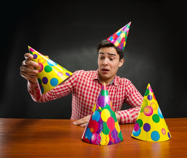 Photo man playing with birthday hats