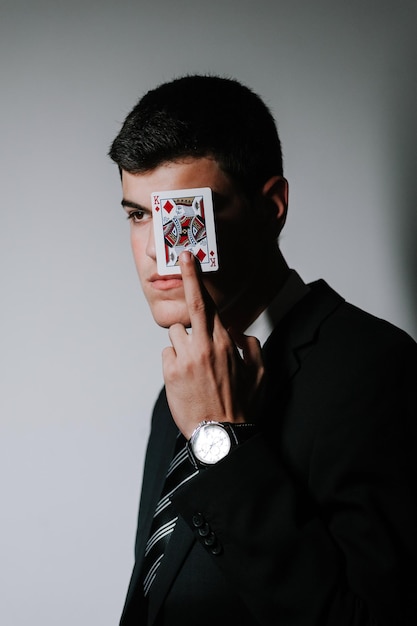 Photo man playing with cards while standing by wall