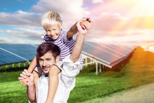 Man playing with a child on the solar panels background