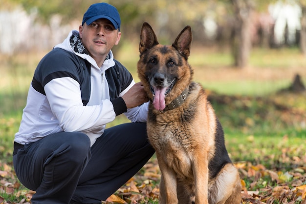 Man Playing With Dog German Shepherd In Park