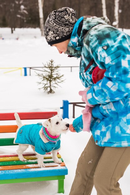 Foto uomo che gioca con il cane sulla neve