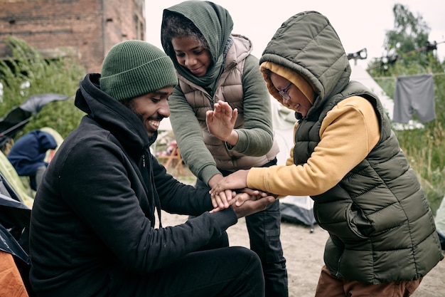 Человек играет с детьми в лагере беженцев