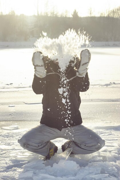 Foto uomo che gioca con la neve sul campo