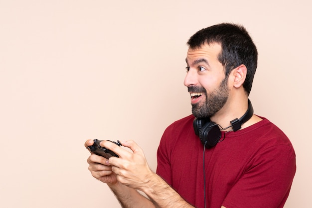 Man playing with a video game controller over isolated wall