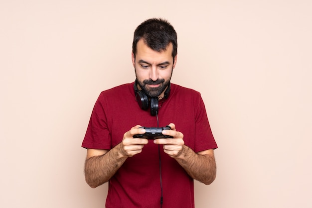 Man playing with a video game controller over isolated wall