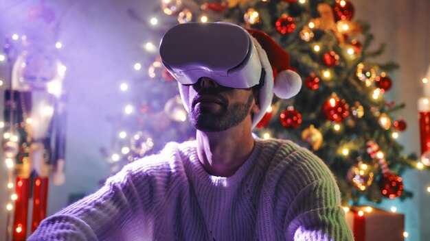 Man playing with virtual reality under christmas tree