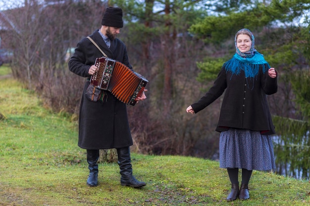 A man plays the accordion for his wife who dances