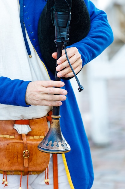 A man plays the bagpipes. close-up