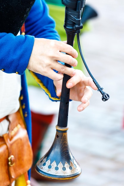 A man plays the bagpipes. close-up