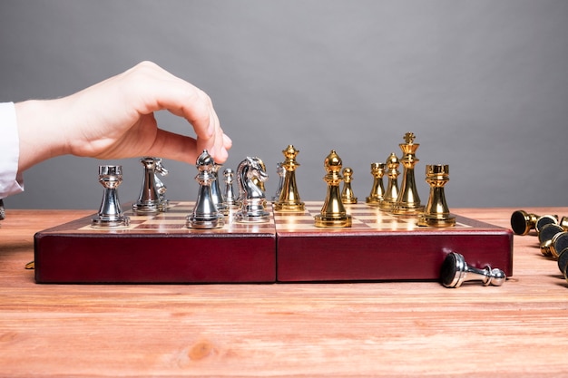 Man plays chess at a wooden table.