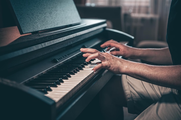 A man plays an electronic piano in a dark room