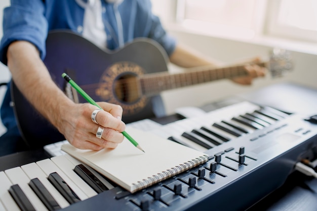 Man plays guitar and produces electronic soundtrack