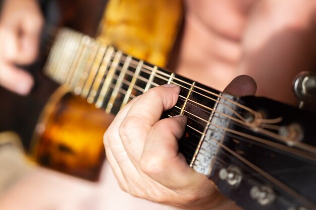A man plays a twelvestring acoustic guitar hobbies and\
entertainment