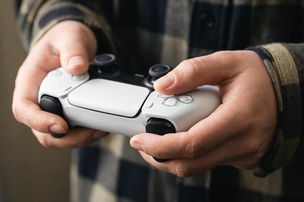 Photo a man plays a video game a gamepad in the hands of a man closeup