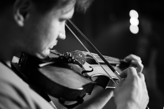 A man plays the violin on the stage of close