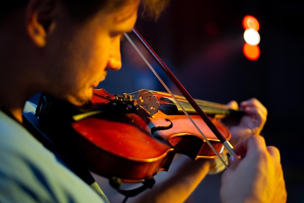 A man plays the violin on the stage of close