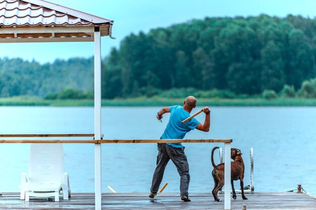 男は犬のボクサーで遊ぶ