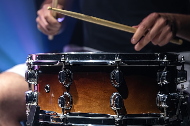 A man plays with sticks on a drum, a drummer plays a percussion instrument, close-up.