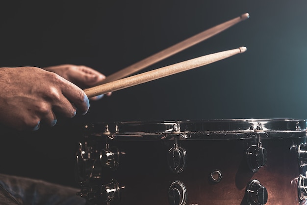 A man plays with sticks on a drum, a drummer plays a percussion instrument, close-up.
