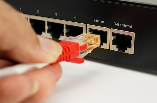 사진 남자는 라우터lan 네트워크 및 인터넷 연결 이더넷 rj45 케이블에 인터넷 케이블을 연결합니다.