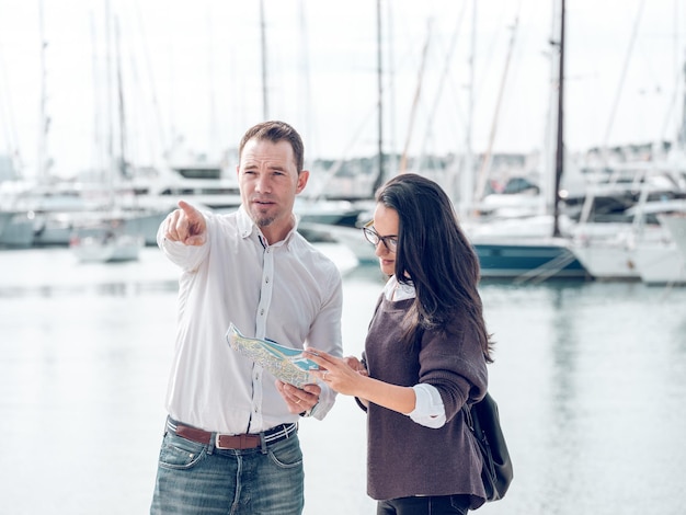 Man pointing away while showing route to woman