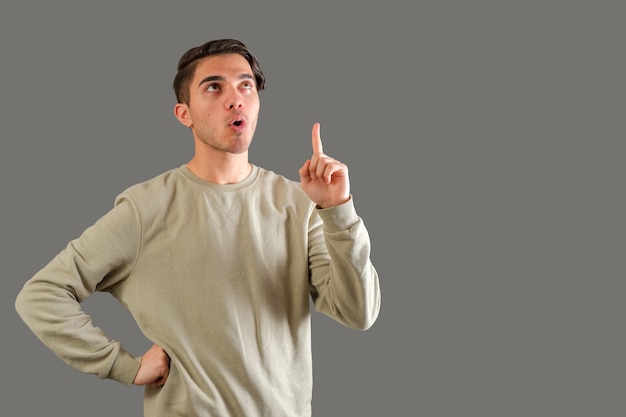 Man pointing finger up isolated on gray background