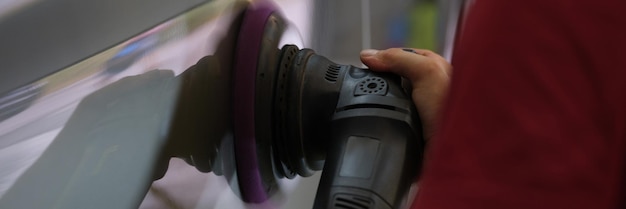 A man polishes the body of a car hands closeup