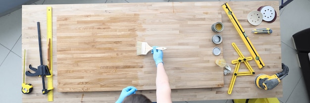 A man polishing a board with varnish top view