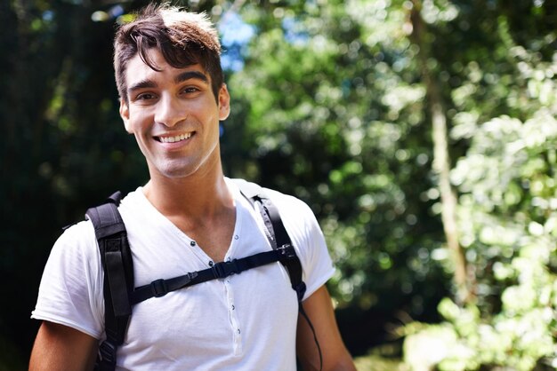 man portrait and backpack for hiking in rainforest with smile for adventure holiday and outdoor in summer person happy and bag for trekking walk and journey in nature for vacation in colombia