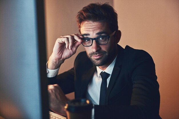 Man portrait and computer for finance at night office and international stock market exchange Male person investment advisor and online to monitor economy growth in London accountant and website