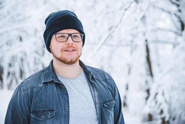 Man portrait in snowed woods glasses and beard