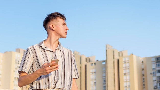 Foto man poseren buitenshuis terwijl smartphone