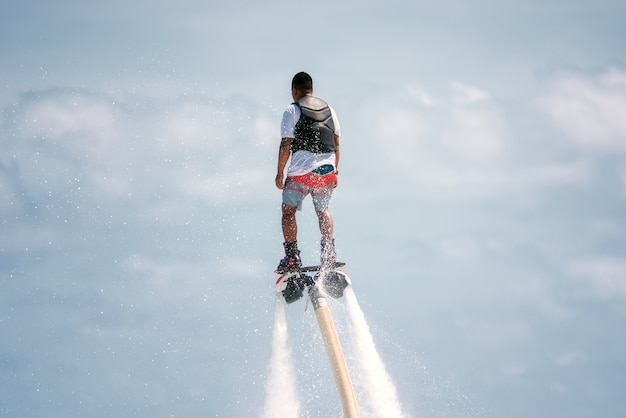 写真 水の極端なフライボードでポーズをとる男。