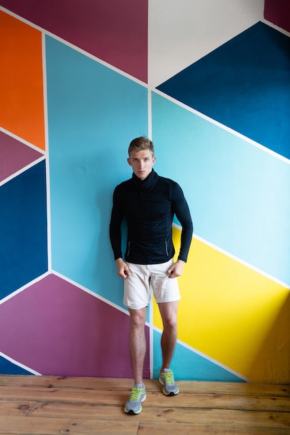 Man posing on the background of a colored wall