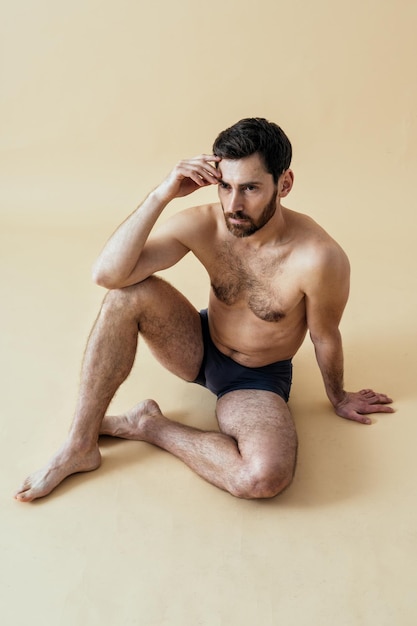 Фото Мужчина позирует для мужского издания телесного положительного набора красоты. парень без рубашки в нижнем белье боксеров в студии