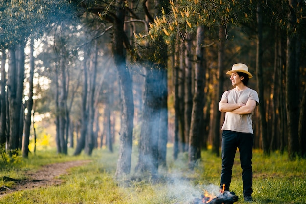 Man posing near firewood in summer forest