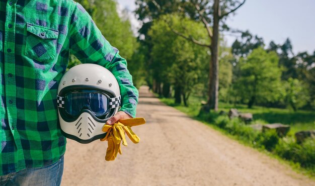 オートバイのヘルメットと手袋でポーズをとる男