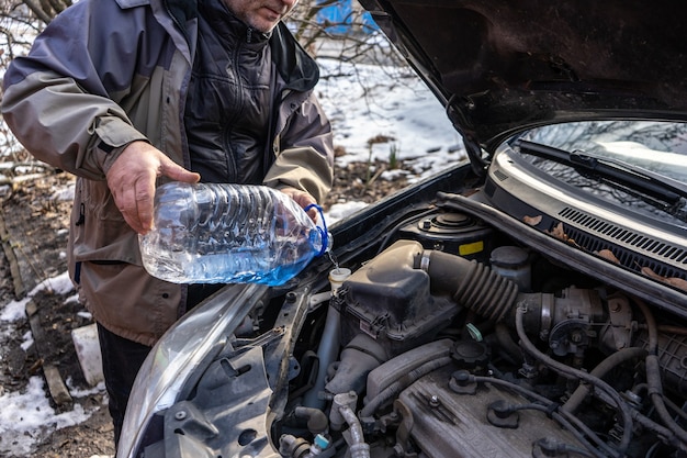 Man pouring antifreeze into special fluid tank