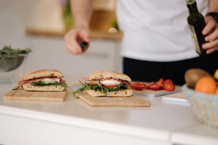 古典的なイタリアのブルスケッタ ビーガンの健康食品にコールドプレス亜麻仁油を注ぐ男性