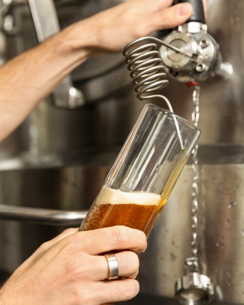 Photo man pouring, filling beer glass, mug from barrel